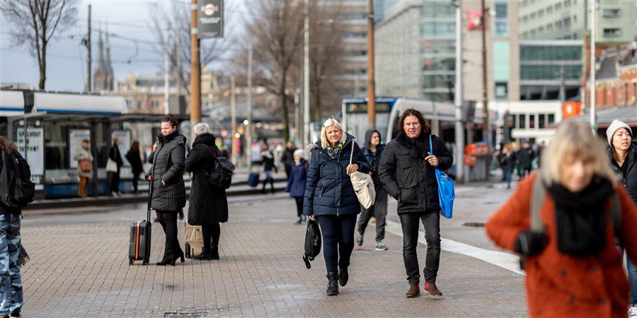 een stel vriendinnen dat voor Amsterdam centraal loopt