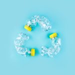 Three,Crashed,Plastic,Bottles,On,Blue,Background,Form,Resycling,Sign.